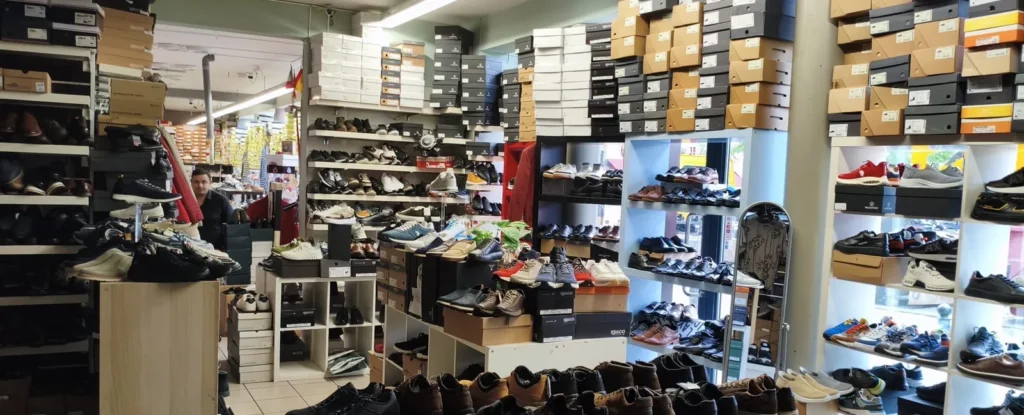 Rayons de boîtes et chaussures exposées chez Outlet Chaussures Bruxelles, place du Jeu de Balle