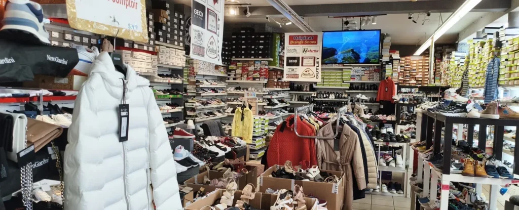 White down jacket on a mannequin in front of the winter shoe shelves at Outlet Chaussures Bruxelles, Place du Jeu de Balle